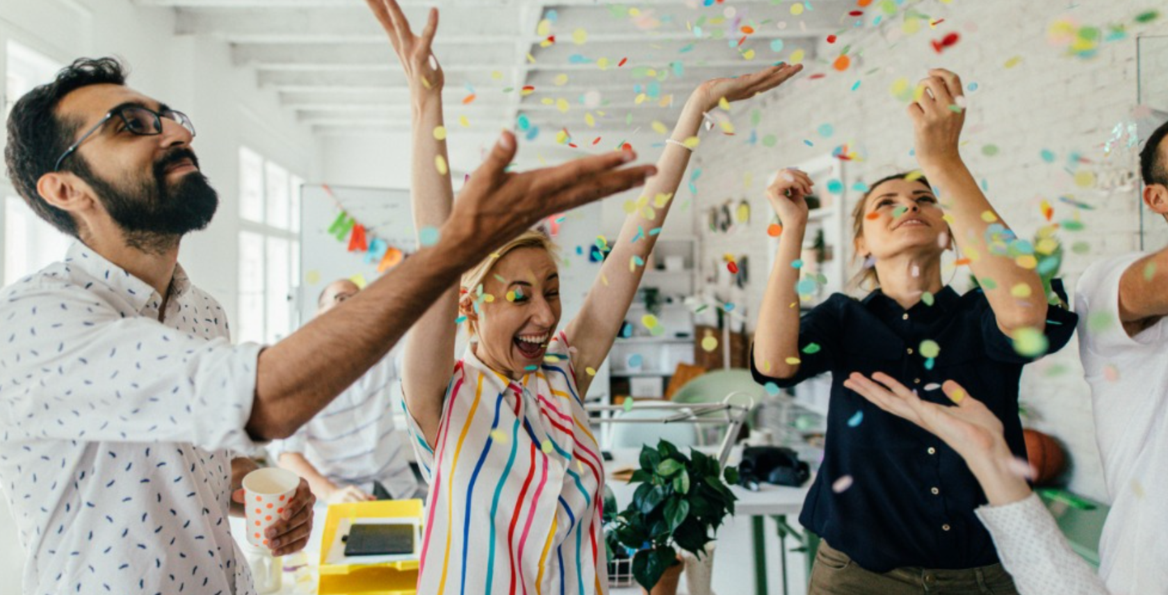 Team celebrating with confetti in bright office space